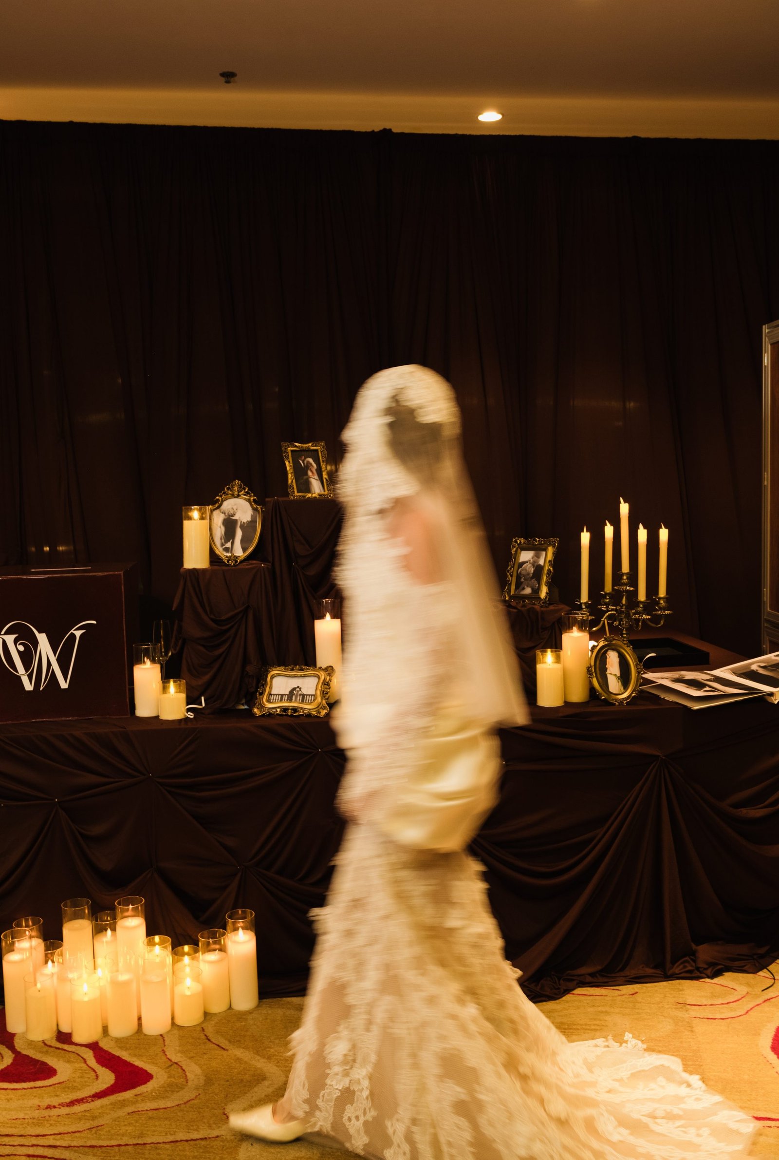 Bride walking past a candlelit memory table