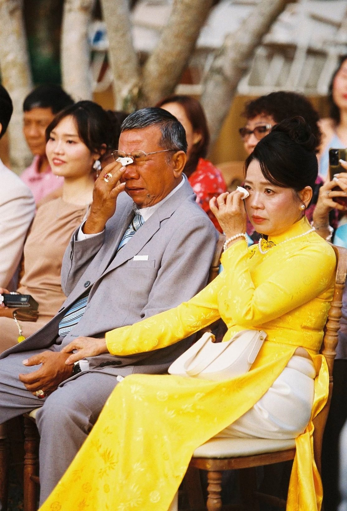 Parents wiping away tears of joy during the ceremony
